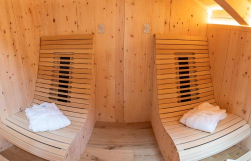 two beds in a room with wooden walls at Madlhof in Himmelreich