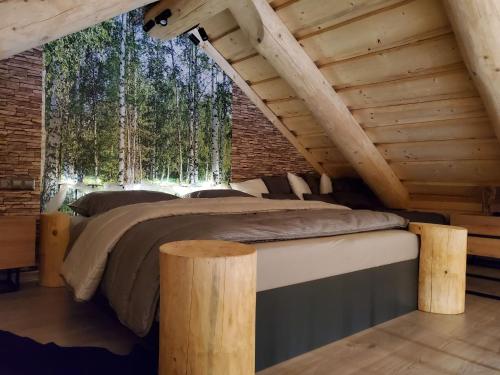 a bedroom in a log cabin with a bed and trees at Chalet KuŘíp by Interhome in Benešov nad Černou