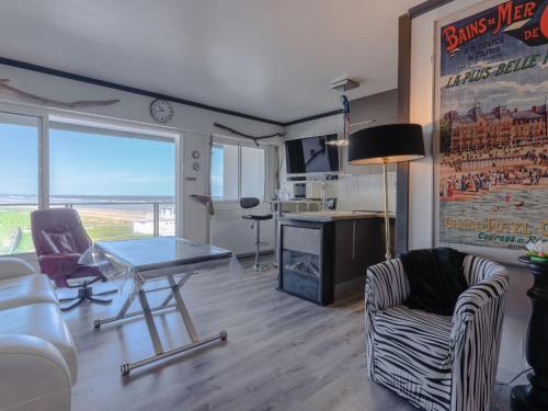 een woonkamer met een tafel en twee stoelen bij Apartment Les Dunes by Interhome in Varaville