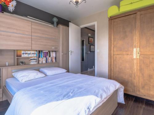 een slaapkamer met een groot bed en een boekenplank bij Apartment Les Dunes by Interhome in Varaville