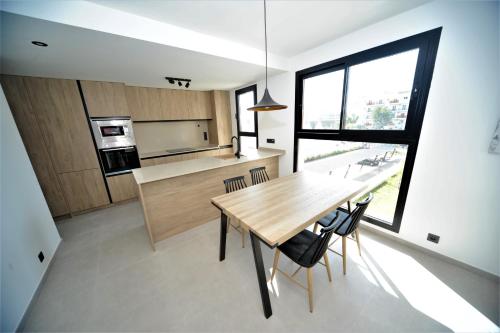 cocina con mesa de madera y ventana grande en BOHIO Premium 3 dormitorios, en Benicàssim