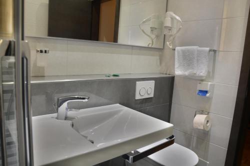 a bathroom with a sink and a mirror at Hotel Fiesa in Piran