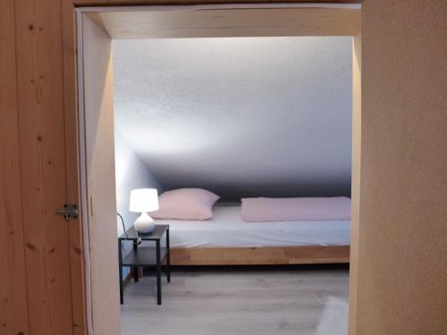 a bedroom with a bed and a table with a lamp at Apartment Chalet Vamika by Interhome in Niederried