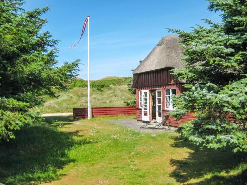 een kleine hut met een vlag ervoor bij Holiday Home Jorid - 300m from the sea in Western Jutland by Interhome in Vejers Strand