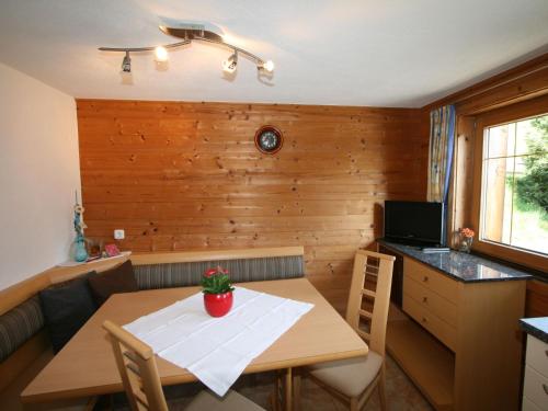 a small dining room with a table and a kitchen at Apartment Tom by Interhome in Schlitters