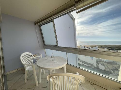 une table et deux chaises dans une pièce avec une fenêtre dans l'établissement Studio à St-Jean-de-Monts avec parking et balcon fermé - FR-1-224C-212, à Saint-Jean-de-Monts