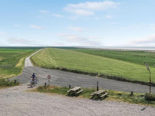 uma pessoa a andar de bicicleta numa estrada com mesas de piquenique em Holiday Home Stilla - 35km from the sea in Western Jutland by Interhome em Højer