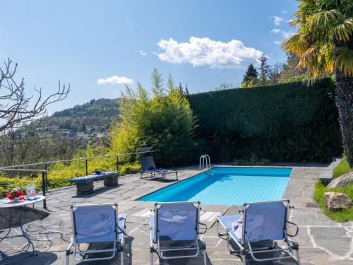a swimming pool with two chairs and a table and a tablektop at Holiday Home Carina Lakeview by Interhome in Carona