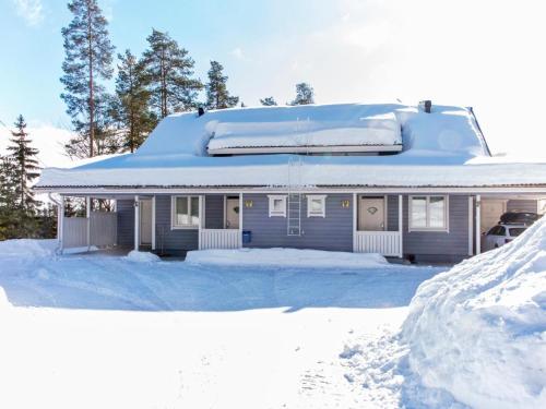 a house covered in snow with a pile of snow at Holiday Home Tahkonkallio 34 b by Interhome in Tahkovuori