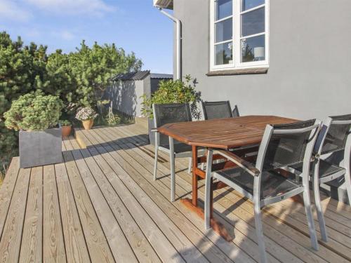 una terraza de madera con mesa y sillas de madera en Holiday Home Sebe - 300m from the sea in Western Jutland by Interhome, en Lakolk