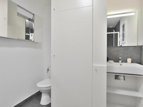 a white bathroom with a toilet and a sink at Holiday Home la k'bane sur mer by Interhome in Étables-sur-Mer