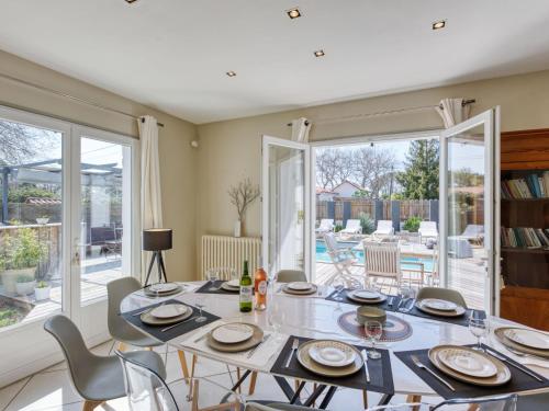 une salle à manger avec une table et des chaises ainsi qu'une terrasse dans l'établissement Villa Andernos Bassin by Interhome, à Andernos-les-Bains