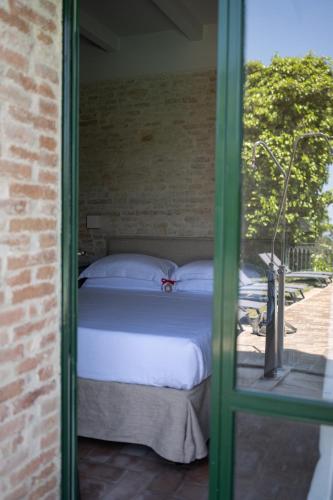 Postel nebo postele na pokoji v ubytování Palazzo Viviani - Castello di Montegridolfo