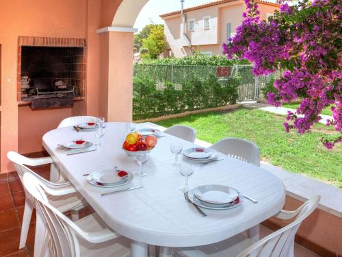 einen weißen Tisch mit weißen Stühlen und einen weißen Tisch mit Brille in der Unterkunft Villa Paraiso by Interhome in L'Ametlla de Mar
