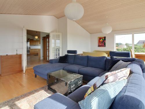 a living room with a blue couch and a table at Holiday Home Amalia - 500m from the sea in NW Jutland by Interhome in Hjørring