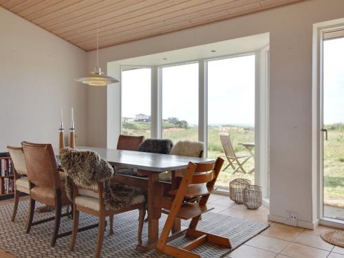 a dining room with a table and chairs at Holiday Home Amalia - 500m from the sea in NW Jutland by Interhome in Hjørring