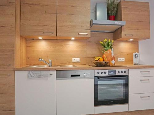 una cucina con elettrodomestici bianchi e armadietti in legno di Apartment Plattner by Interhome a Oetz