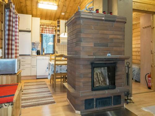 a living room with a brick fireplace in a kitchen at Holiday Home Naalitupa by Interhome in Saariselka