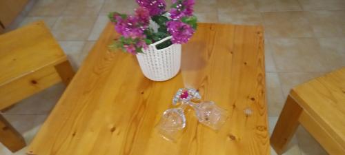 a wooden table with a vase of flowers on it at Txada Hostel in Praia