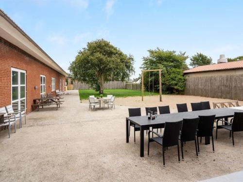 a patio with a table and chairs and a playground at Holiday Home Saga by Interhome in Bredebro