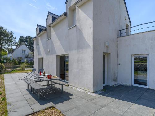un patio avec une table et des bancs à côté d'un bâtiment dans l'établissement Holiday Home Maison Le Guernic by Interhome, à Portivy