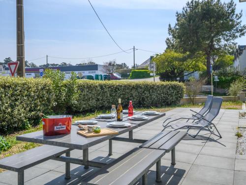 une table de pique-nique avec deux chaises et des bouteilles de bière dans l'établissement Holiday Home Maison Le Guernic by Interhome, à Portivy