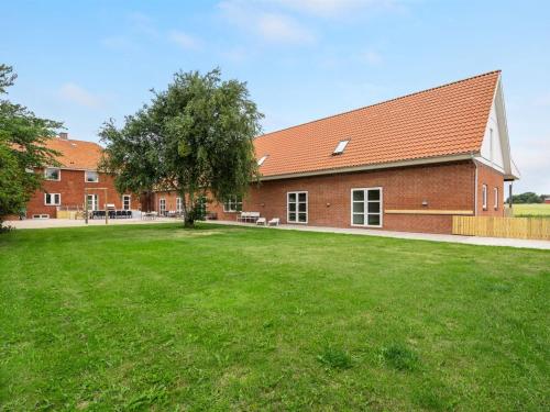 a brick building with a large yard in front of it at Holiday Home Saga by Interhome in Bredebro