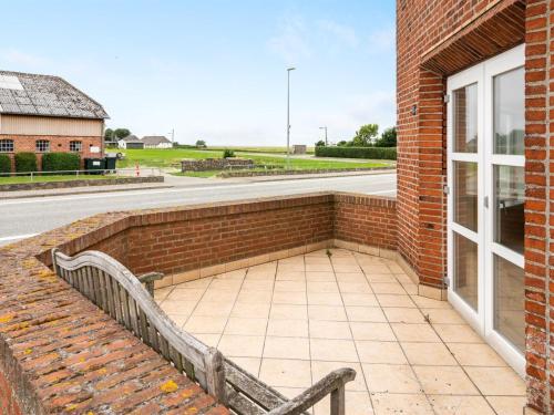 a bench next to a brick building with a window at Holiday Home Saga by Interhome in Bredebro