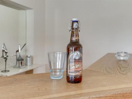 a bottle of beer next to a glass on a table at Holiday Home Saga by Interhome in Bredebro