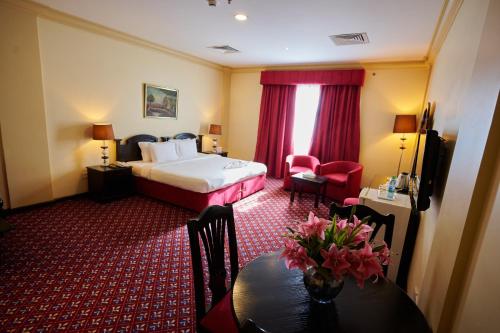 a hotel room with a bed and a table at La Rosa Hotel, Juffair in Manama