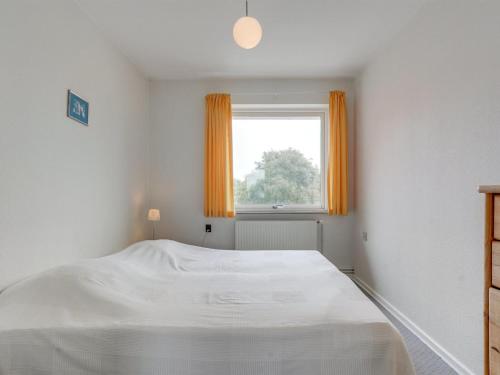 a white bedroom with a bed and a window at Holiday Home Saga by Interhome in Bredebro