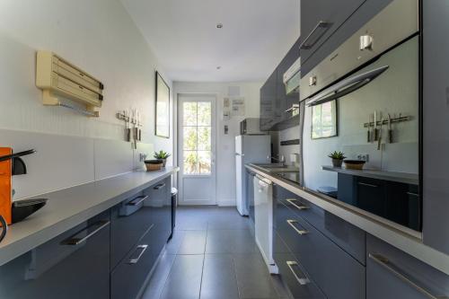 une grande cuisine avec des placards bleus et blancs dans l'établissement Villa Amandine - Charmante maison de famille au Pyla, à Arcachon