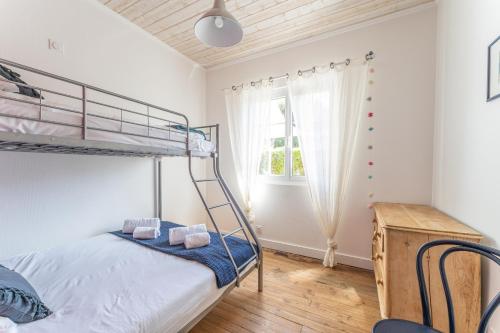 une chambre avec un lit superposé et une fenêtre dans l'établissement Villa Amandine - Charmante maison de famille au Pyla, à Arcachon