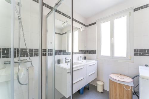 une salle de bain blanche avec une douche et un lavabo dans l'établissement Villa Amandine - Charmante maison de famille au Pyla, à Arcachon
