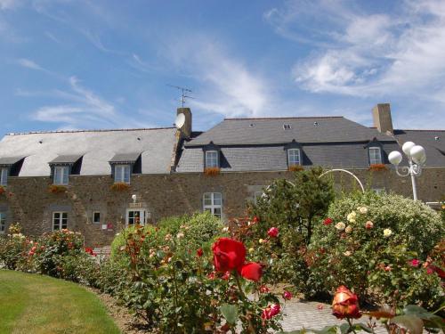 a large house with a bunch of flowers in front of it at Apartment La Bisquine by Interhome in Saint-Jouan-des-Guérets