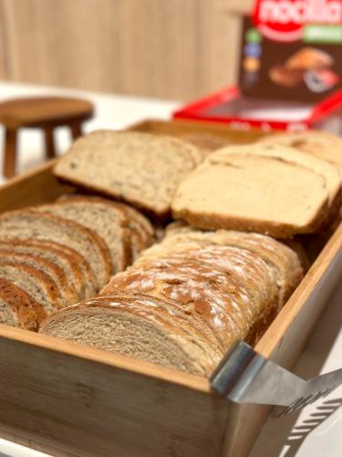 a loaf of bread in a wooden box with a knife at Turia Valencia in Valencia