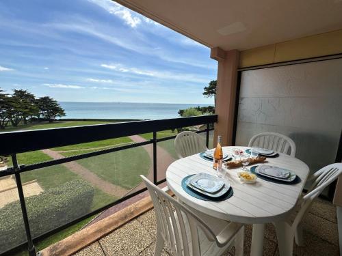 ein weißer Tisch und Stühle auf einem Balkon mit Blick auf das Meer in der Unterkunft Apartment Claire Marine by Interhome in Pornic