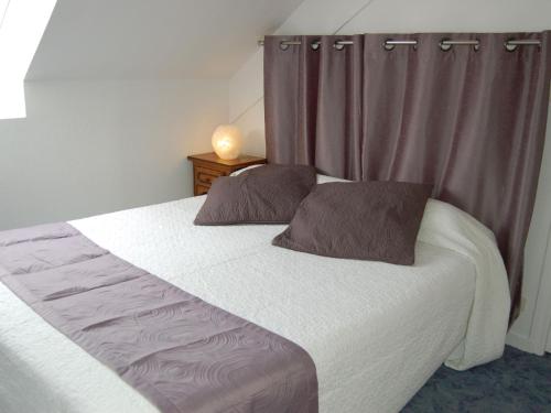 un lit avec deux oreillers dessus dans une chambre dans l'établissement Apartment La Malouinière des Longchamps by Interhome, à Saint-Jouan-des-Guérets