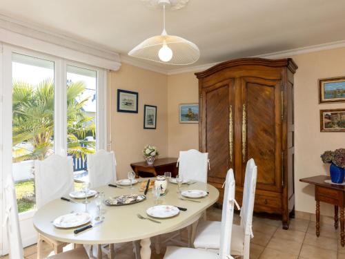 une salle à manger avec une table et des chaises blanches dans l'établissement Holiday Home Karome by Interhome, à Saint-Coulomb