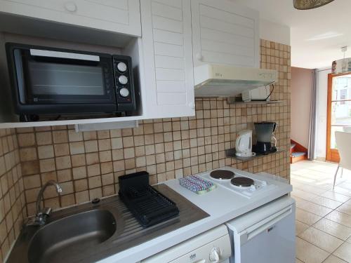 a kitchen with a sink and a microwave at Apartment L' Hermine by Interhome in Saint-Jouan-des-Guérets