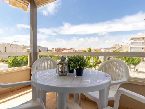 una mesa blanca y sillas en un balcón con vistas en Apartment Girona by Interhome, en Cubelles