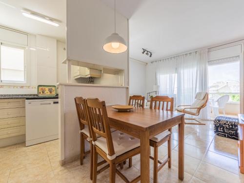 cocina y comedor con mesa de madera y sillas en Apartment Girona by Interhome, en Cubelles