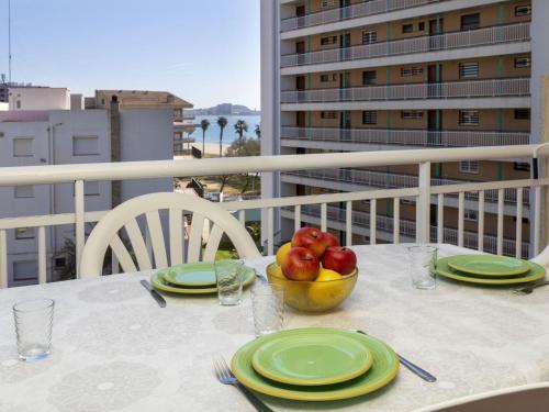- une table avec des assiettes et un bol de fruits sur le balcon dans l'établissement Apartment Montseny by Interhome, à Sant Antoni de Calonge