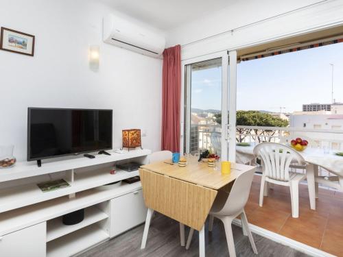 - un salon avec une table à manger et une télévision dans l'établissement Apartment Montseny by Interhome, à Sant Antoni de Calonge