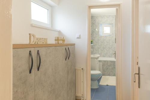 baño con lavabo y aseo y ventana en Luxury 2 bedroom holiday apartment en Piteşti