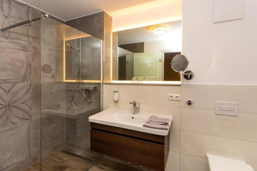 a bathroom with a sink and a shower at Appartementhäuser Achterwasserblick in Ostseebad Koserow