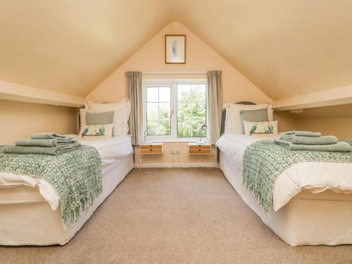 2 camas en un ático con ventana en Charlesworth, en Ashford