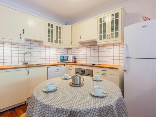 une cuisine avec une table et un réfrigérateur blanc dans l'établissement Apartment Le Bourret-4 by Interhome, à Soorts-Hossegor