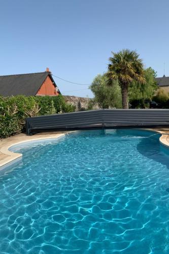 une piscine avec de l'eau bleue devant une maison dans l'établissement Holiday Home La houle by Interhome, à Cancale