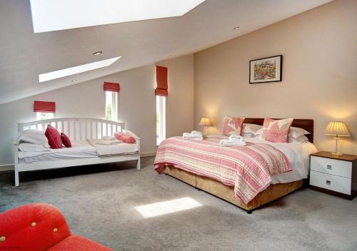 a bedroom with two beds and a chair in it at Beadnell Beach House in Beadnell